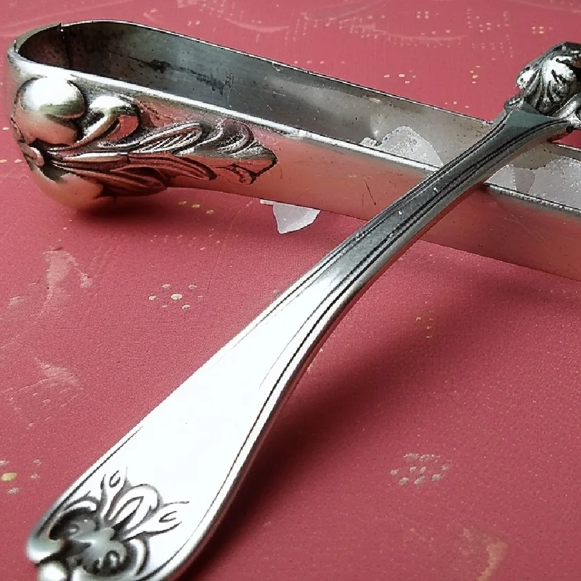 Silver sugar tongs with intricate design